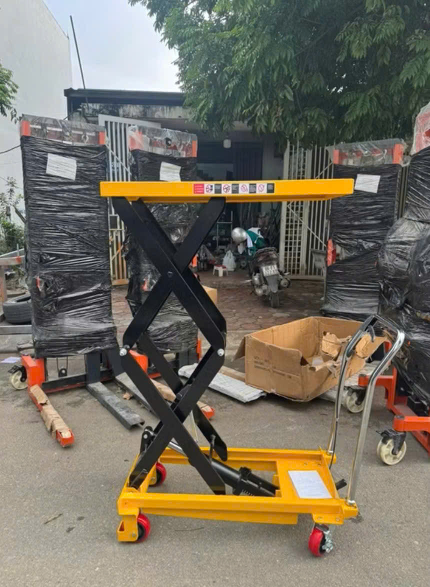 Bàn nâng thủy lực dạng cắt kéo màu vàng đen có bánh xe dùng nâng hàng trong kho xưởng